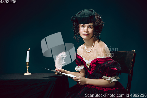 Image of Young woman as Anna Karenina on dark blue background. Retro style, comparison of eras concept.