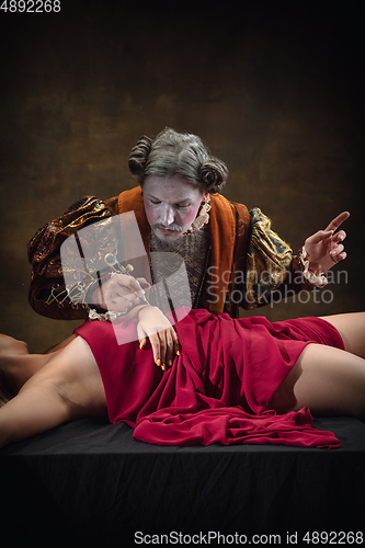 Image of Young man as Johann Sebastian Bach on dark green background. Retro style, comparison of eras concept.