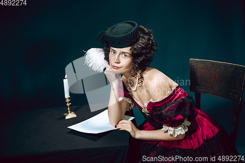 Image of Young woman as Anna Karenina on dark blue background. Retro style, comparison of eras concept.