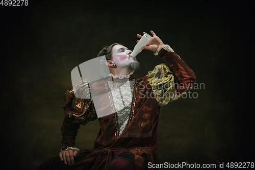 Image of Young man as Johann Sebastian Bach on dark green background. Retro style, comparison of eras concept.