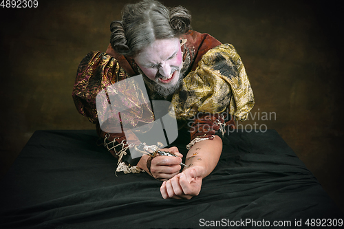 Image of Young man as Johann Sebastian Bach on dark green background. Retro style, comparison of eras concept.
