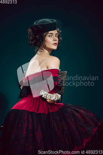 Image of Young woman as Anna Karenina on dark blue background. Retro style, comparison of eras concept.