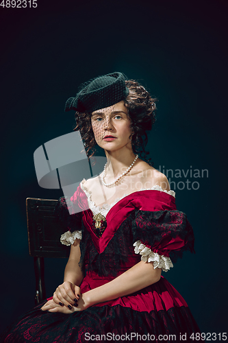 Image of Young woman as Anna Karenina on dark blue background. Retro style, comparison of eras concept.