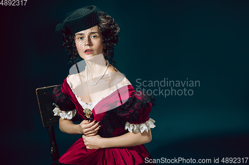 Image of Young woman as Anna Karenina on dark blue background. Retro style, comparison of eras concept.