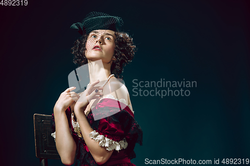 Image of Young woman as Anna Karenina on dark blue background. Retro style, comparison of eras concept.