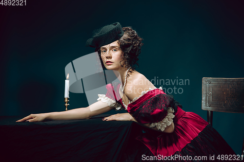 Image of Young woman as Anna Karenina on dark blue background. Retro style, comparison of eras concept.