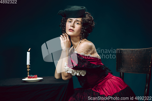 Image of Young woman as Anna Karenina on dark blue background. Retro style, comparison of eras concept.