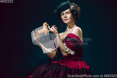 Image of Young woman as Anna Karenina on dark blue background. Retro style, comparison of eras concept.