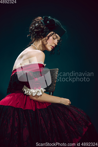 Image of Young woman as Anna Karenina on dark blue background. Retro style, comparison of eras concept.