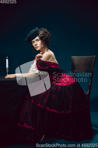 Image of Young woman as Anna Karenina on dark blue background. Retro style, comparison of eras concept.