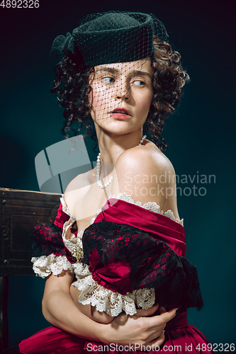 Image of Young woman as Anna Karenina on dark blue background. Retro style, comparison of eras concept.