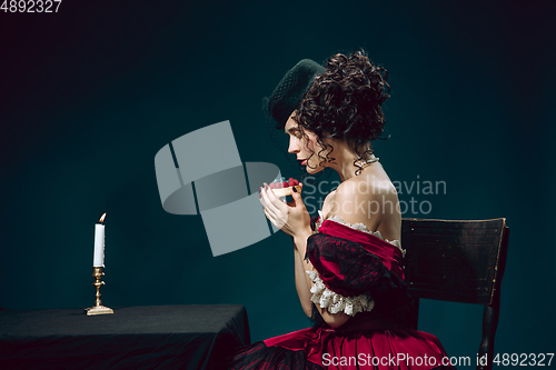 Image of Young woman as Anna Karenina on dark blue background. Retro style, comparison of eras concept.