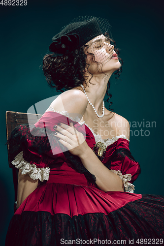 Image of Young woman as Anna Karenina on dark blue background. Retro style, comparison of eras concept.