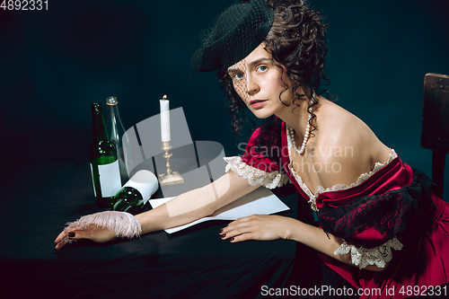 Image of Young woman as Anna Karenina on dark blue background. Retro style, comparison of eras concept.