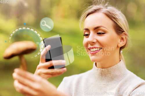 Image of woman using smartphone to identify mushroom