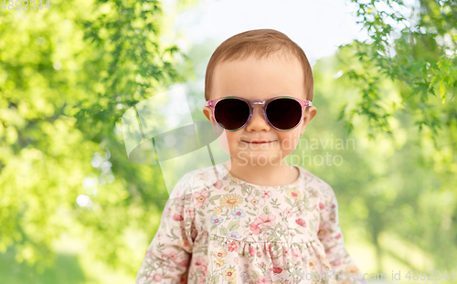 Image of happy little baby girl in sunglasses over nature