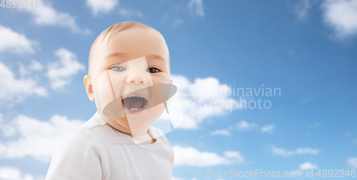 Image of portrait of happy laughing little baby over sky