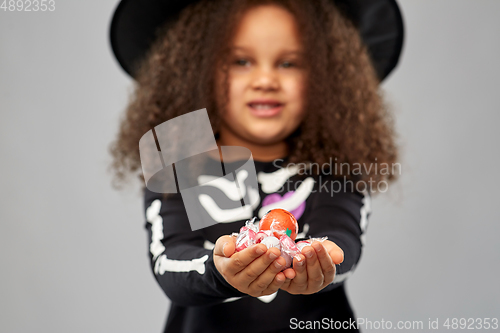 Image of girl with candies trick-or-treating on halloween