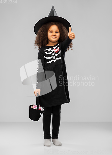 Image of girl with candies trick-or-treating on halloween