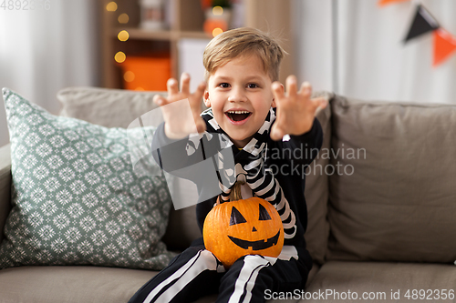 Image of happy boy in halloween costume of skeleton at home