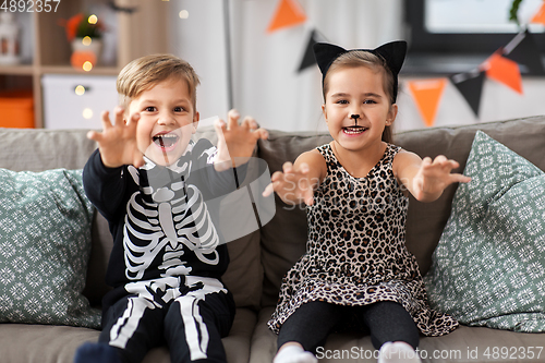 Image of kids in halloween costumes having fun at home