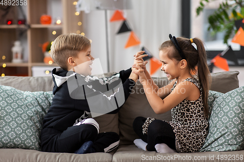 Image of kids in halloween costumes having fun at home