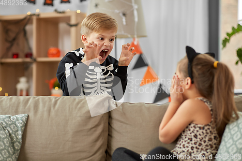 Image of kids in halloween costumes playing at home