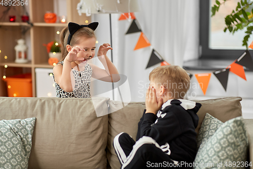 Image of kids in halloween costumes playing at home