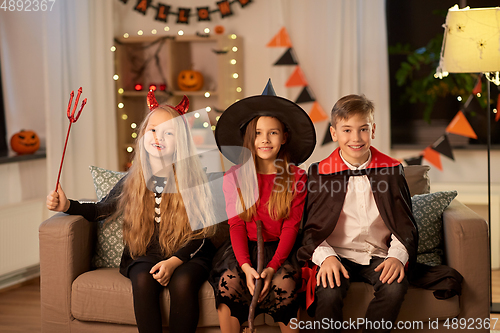 Image of kids in halloween costumes at home at night