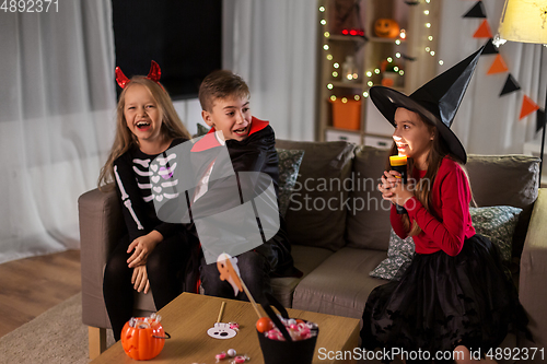 Image of kids in halloween costumes playing at home