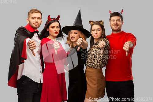 Image of friends in halloween costumes snow thumbs down