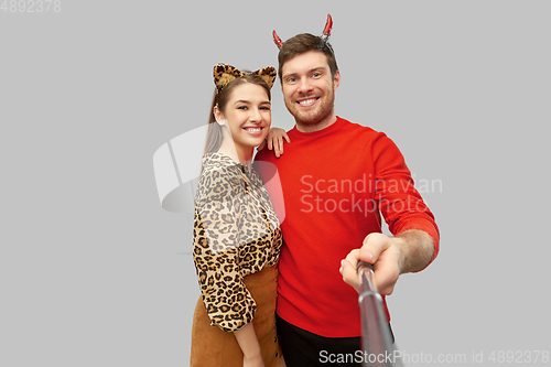 Image of happy couple in halloween costumes taking selfie