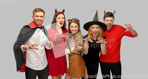 Image of friends in halloween costumes scaring