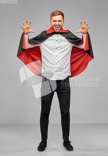 Image of man in halloween costume of vampire scaring