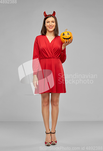 Image of woman in halloween costume of devil with pumpkin