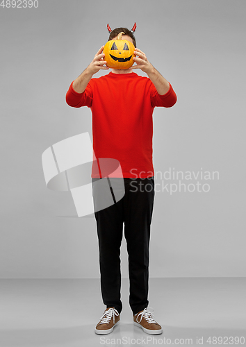 Image of happy man in halloween costume of devil over grey