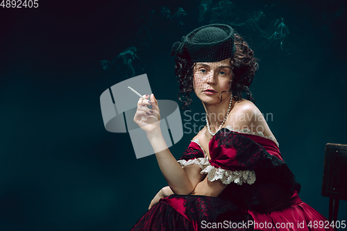 Image of Young woman as Anna Karenina on dark blue background. Retro style, comparison of eras concept.