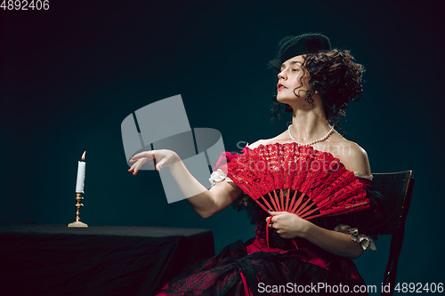 Image of Young woman as Anna Karenina on dark blue background. Retro style, comparison of eras concept.