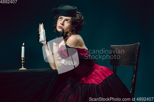 Image of Young woman as Anna Karenina on dark blue background. Retro style, comparison of eras concept.