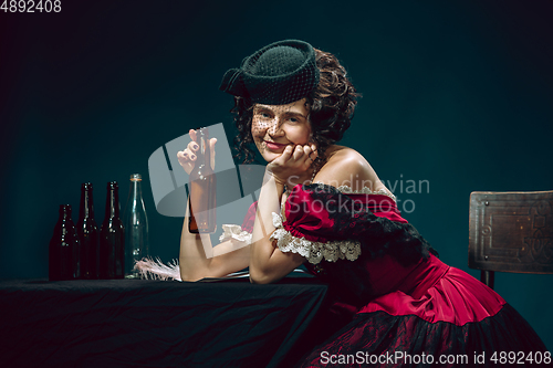 Image of Young woman as Anna Karenina on dark blue background. Retro style, comparison of eras concept.