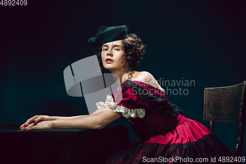 Image of Young woman as Anna Karenina on dark blue background. Retro style, comparison of eras concept.