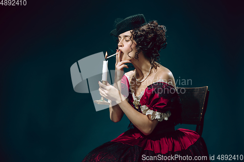 Image of Young woman as Anna Karenina on dark blue background. Retro style, comparison of eras concept.