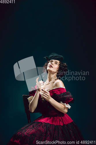 Image of Young woman as Anna Karenina on dark blue background. Retro style, comparison of eras concept.