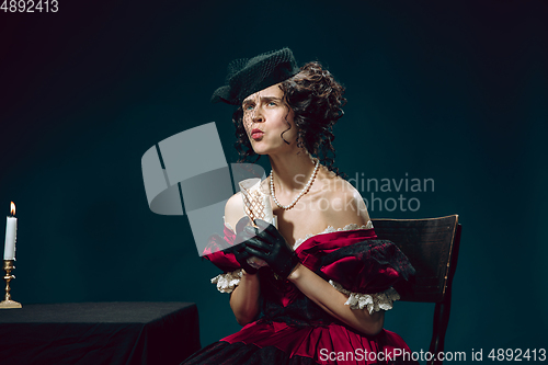 Image of Young woman as Anna Karenina on dark blue background. Retro style, comparison of eras concept.