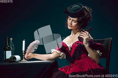 Image of Young woman as Anna Karenina on dark blue background. Retro style, comparison of eras concept.