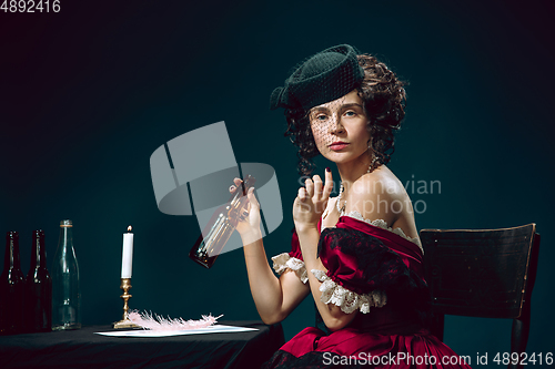 Image of Young woman as Anna Karenina on dark blue background. Retro style, comparison of eras concept.