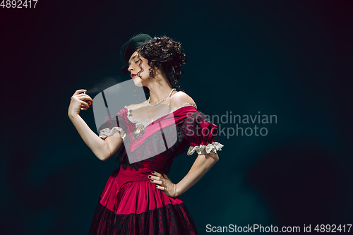 Image of Young woman as Anna Karenina on dark blue background. Retro style, comparison of eras concept.