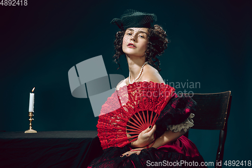 Image of Young woman as Anna Karenina on dark blue background. Retro style, comparison of eras concept.