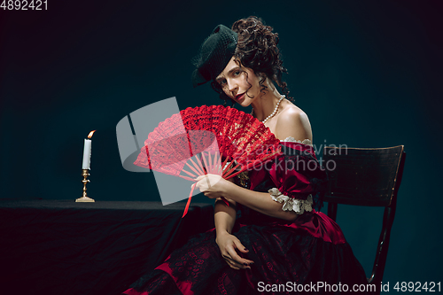 Image of Young woman as Anna Karenina on dark blue background. Retro style, comparison of eras concept.