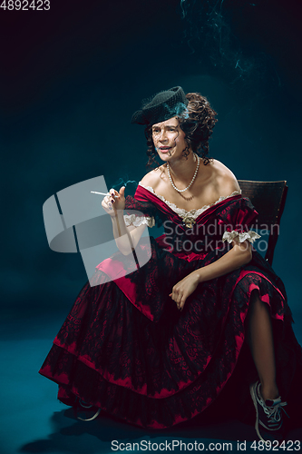 Image of Young woman as Anna Karenina on dark blue background. Retro style, comparison of eras concept.